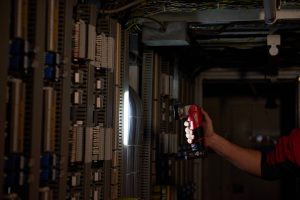 Milwaukee M12 LED torch in use in a dark workshop